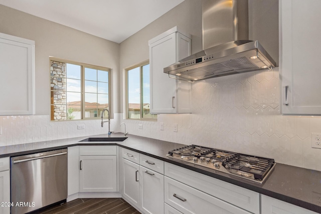 kitchen featuring white cabinets, stainless steel appliances, wall chimney exhaust hood, and sink