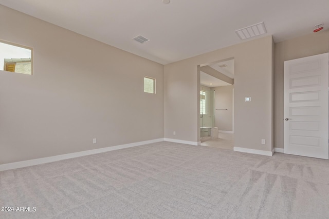 unfurnished room featuring light carpet