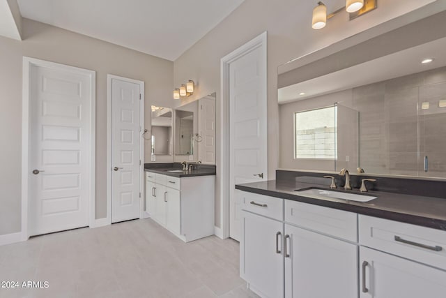 bathroom featuring a tile shower, vanity, and tile patterned floors