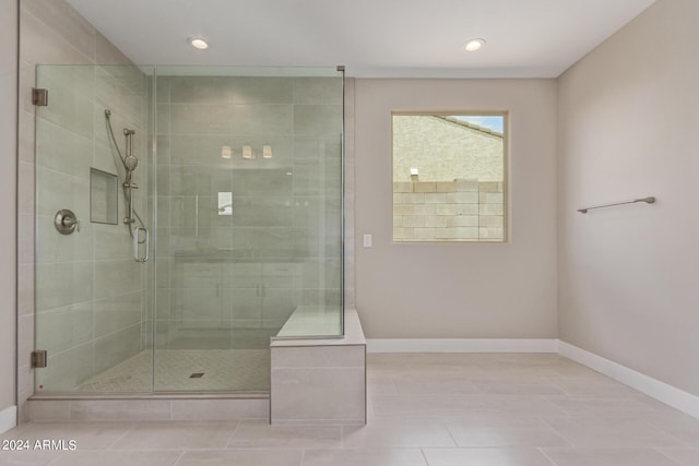 bathroom with tile patterned floors and a shower with door