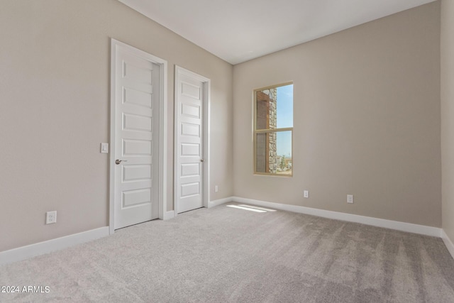 unfurnished bedroom featuring light carpet