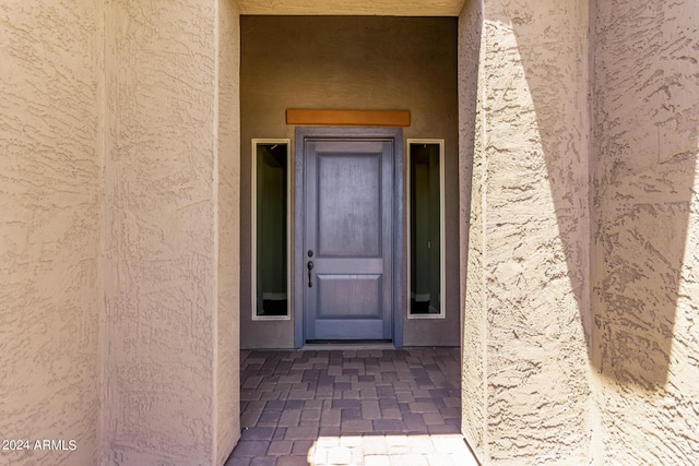 entrance to property featuring stucco siding