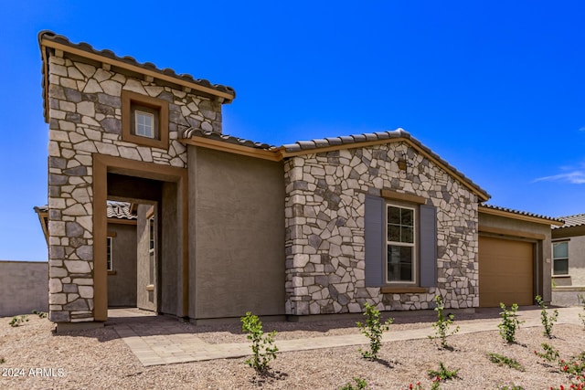 20755 W San Miguel Ave, Buckeye, AZ 85396 - view of front of property with stucco siding, stone siding, an attached garage, and a tile roof