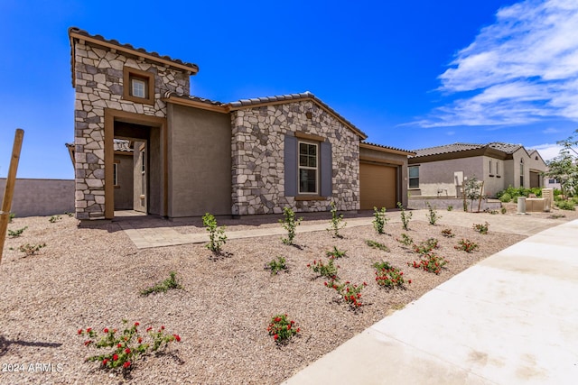 20755 W San Miguel Ave, Buckeye, AZ 85396 - view of front of house featuring an attached garage, stucco siding, concrete driveway, stone siding, and a tiled roof