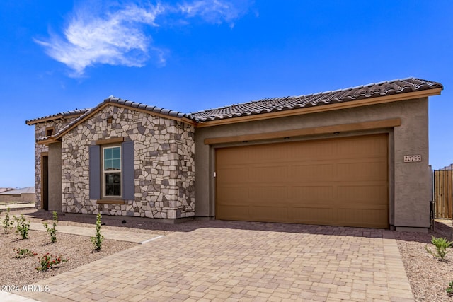 20755 W San Miguel Ave, Buckeye, AZ 85396 - view of front facade with decorative driveway, stone siding, a garage, and stucco siding