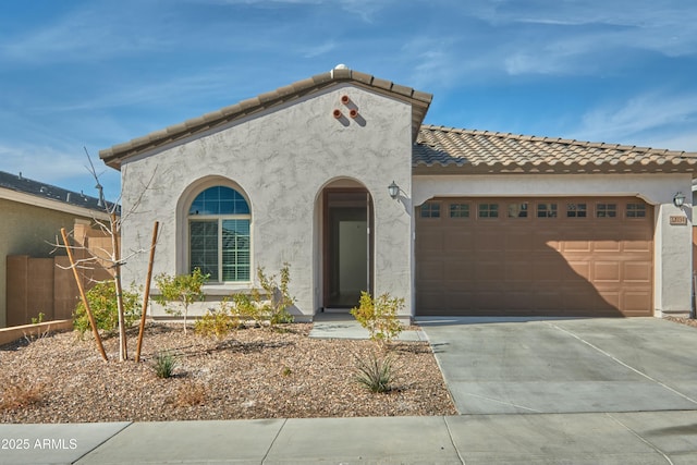 mediterranean / spanish-style home featuring a garage, driveway, a tile roof, and stucco siding