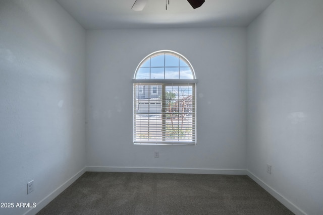 empty room featuring dark colored carpet and ceiling fan