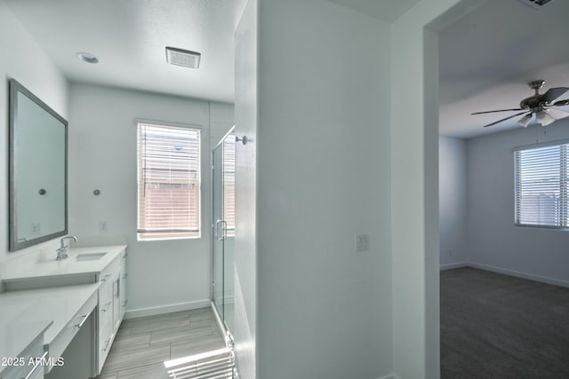 bathroom featuring vanity, an enclosed shower, and ceiling fan