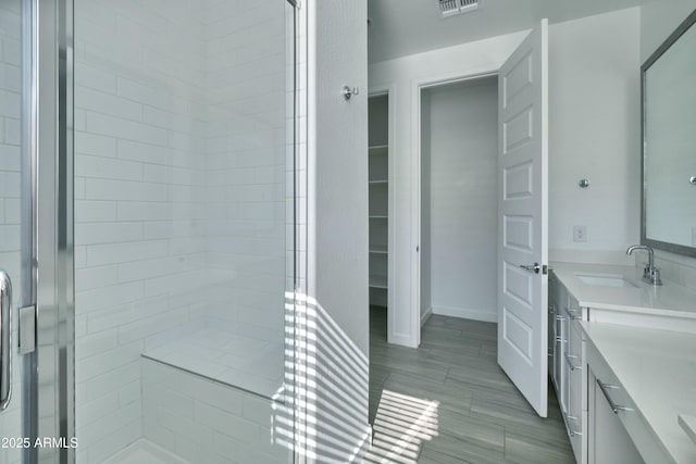 bathroom featuring walk in shower and vanity