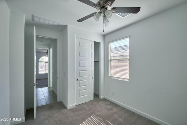 unfurnished bedroom with ceiling fan, carpet floors, and a closet