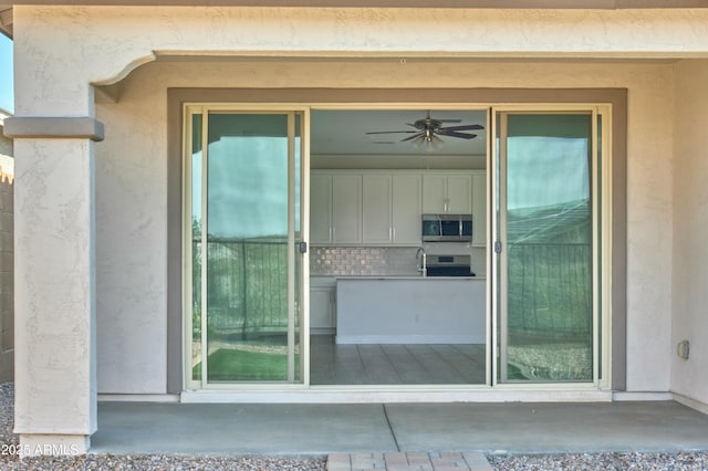 property entrance featuring ceiling fan, sink, and a patio