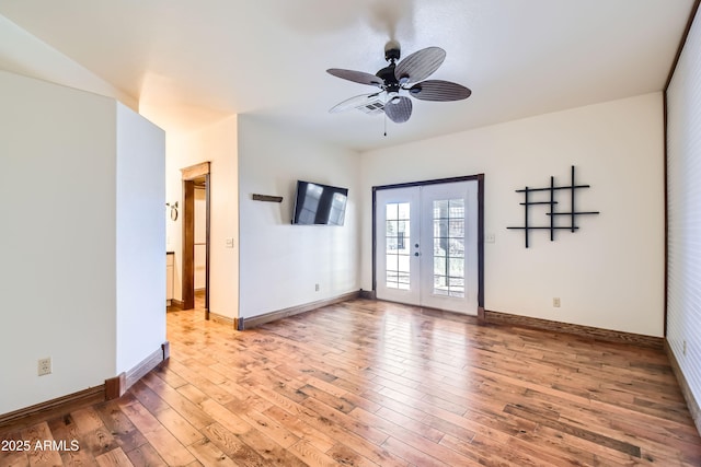 empty room with ceiling fan, french doors, and hardwood / wood-style flooring