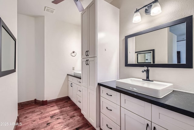 bathroom with vanity, hardwood / wood-style flooring, and ceiling fan