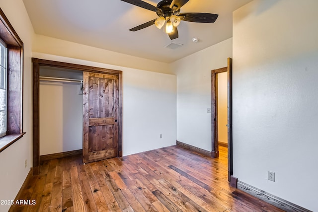 unfurnished bedroom featuring a closet, hardwood / wood-style flooring, and ceiling fan