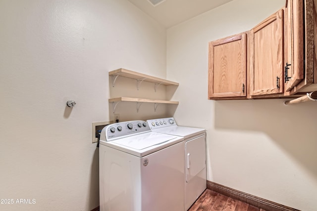 laundry room featuring washer and dryer, dark hardwood / wood-style flooring, and cabinets