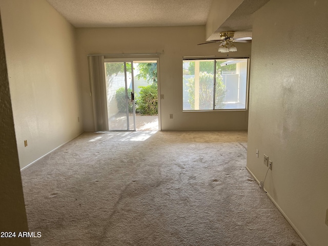 carpeted empty room featuring ceiling fan, a textured ceiling, and beam ceiling