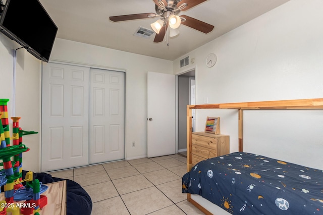 bedroom featuring ceiling fan, light tile patterned floors, and a closet