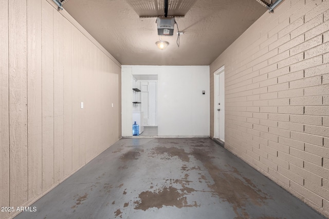 garage with a garage door opener and wooden walls