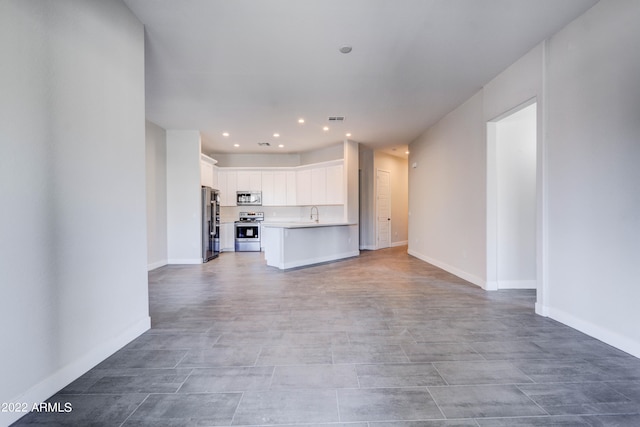 unfurnished living room with light tile floors and sink