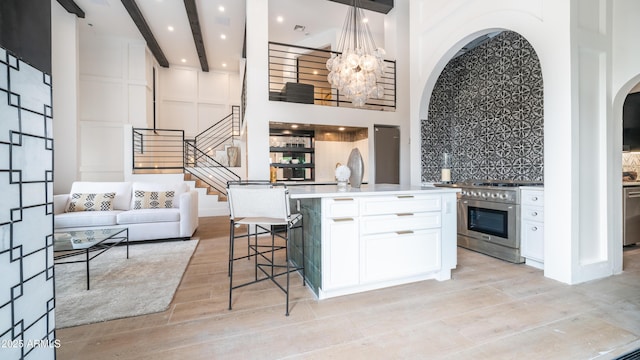 kitchen featuring light wood-style flooring, appliances with stainless steel finishes, backsplash, and white cabinets