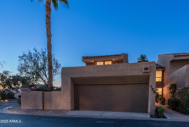 4434 E Camelback Rd Unit 128, Phoenix, AZ 85018 - view of front of property featuring stucco siding, an attached garage, and a gate