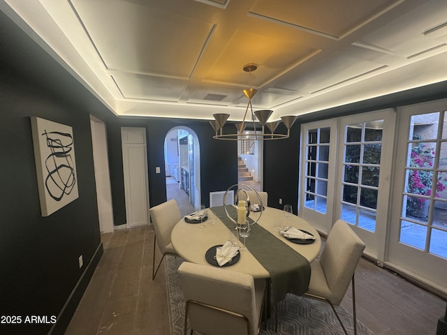 dining room with an inviting chandelier, coffered ceiling, visible vents, dark wood finished floors, and arched walkways