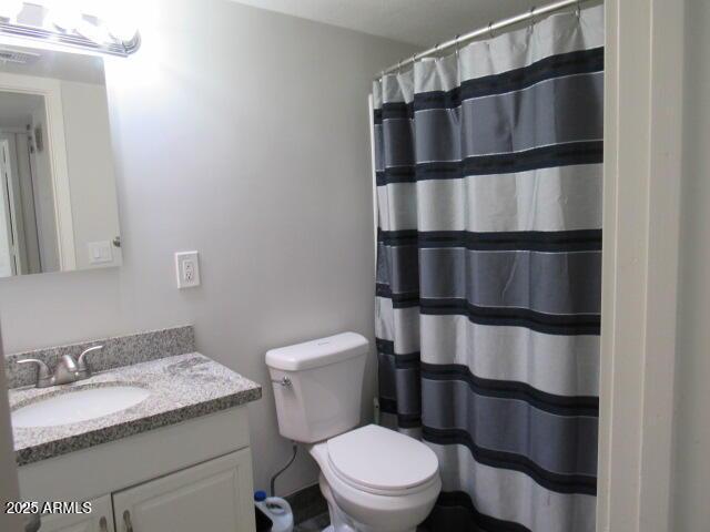 bathroom with toilet, vanity, and a shower with curtain