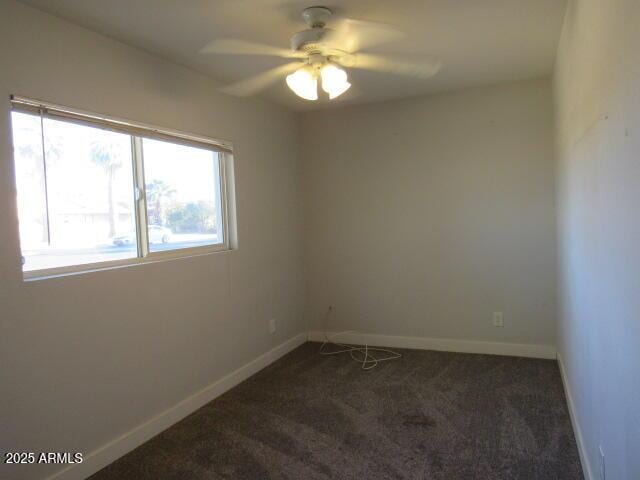 carpeted spare room featuring ceiling fan and a wealth of natural light