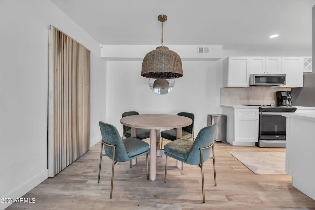 dining space with light hardwood / wood-style flooring