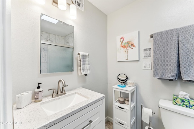 bathroom featuring toilet, an enclosed shower, and vanity