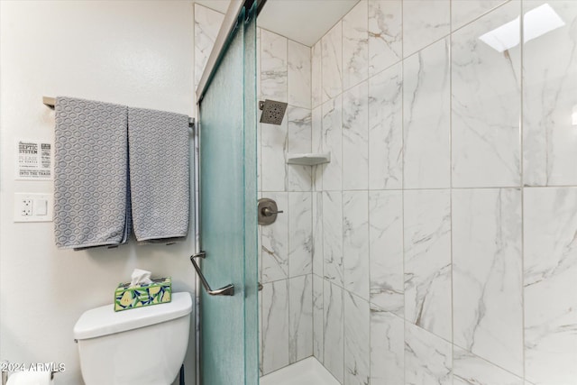 bathroom featuring toilet and a shower with shower door