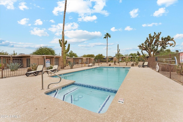 view of pool with a patio and a hot tub