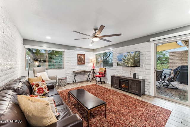 living room with light hardwood / wood-style floors, a fireplace, and ceiling fan