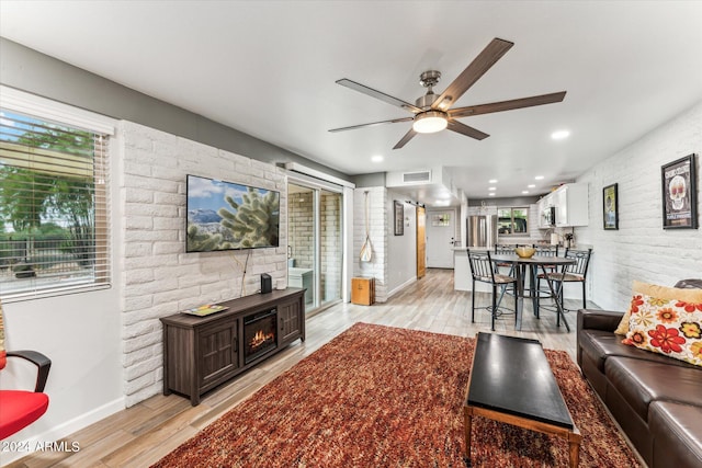 living room with light wood-type flooring and ceiling fan