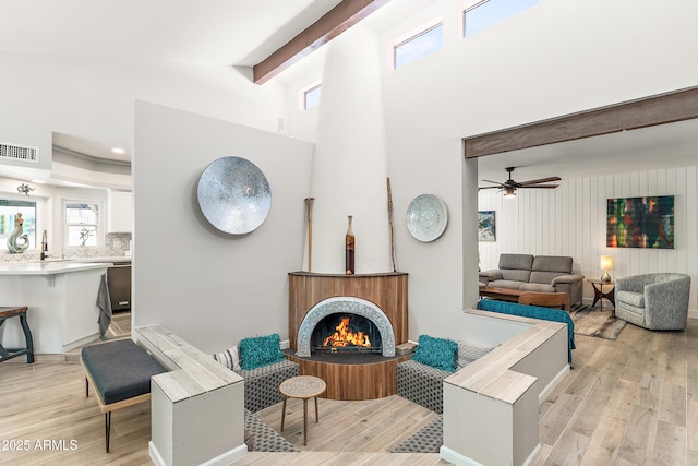 10838 N 10th St, Phoenix, AZ 85020 - living room with light wood finished floors, plenty of natural light, a high ceiling, a lit fireplace, and beamed ceiling