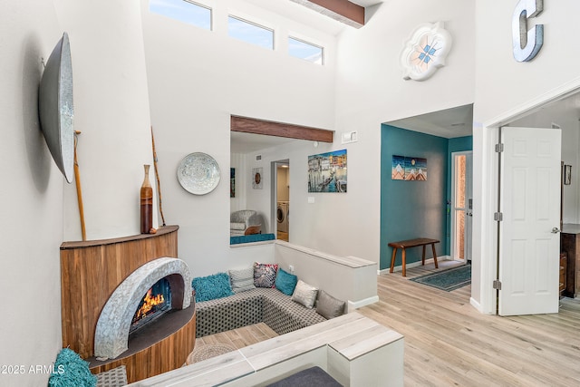 10838 N 10th St, Phoenix, AZ 85020 - living area with a towering ceiling, washer / dryer, light wood finished floors, and baseboards