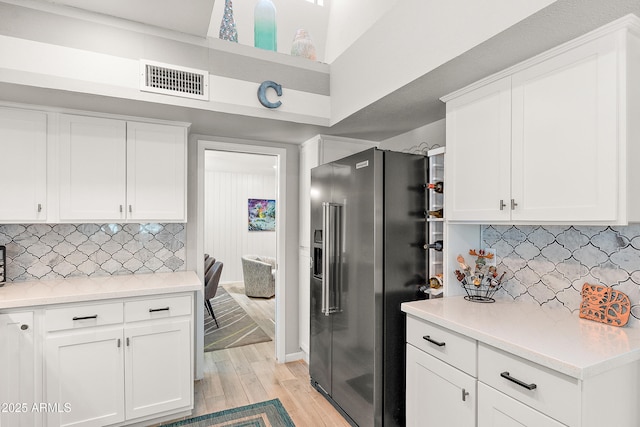 10838 N 10th St, Phoenix, AZ 85020 - kitchen featuring high quality fridge, light wood finished floors, white cabinetry, decorative backsplash, and a towering ceiling