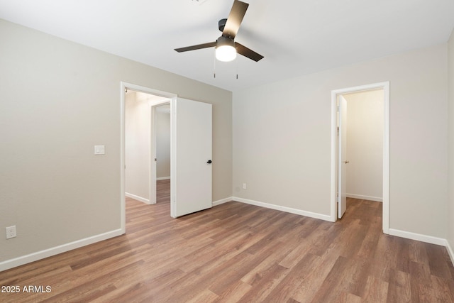 7503 W Julie Dr, Glendale, AZ 85308 - unfurnished bedroom featuring light wood-type flooring, baseboards, ceiling fan, and a walk in closet