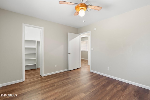 7503 W Julie Dr, Glendale, AZ 85308 - unfurnished bedroom featuring a walk in closet, wood finished floors, baseboards, a closet, and a ceiling fan