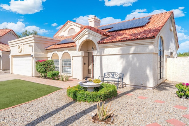 7503 W Julie Dr, Glendale, AZ 85308 - mediterranean / spanish-style house featuring roof mounted solar panels, a tile roof, a chimney, and stucco siding