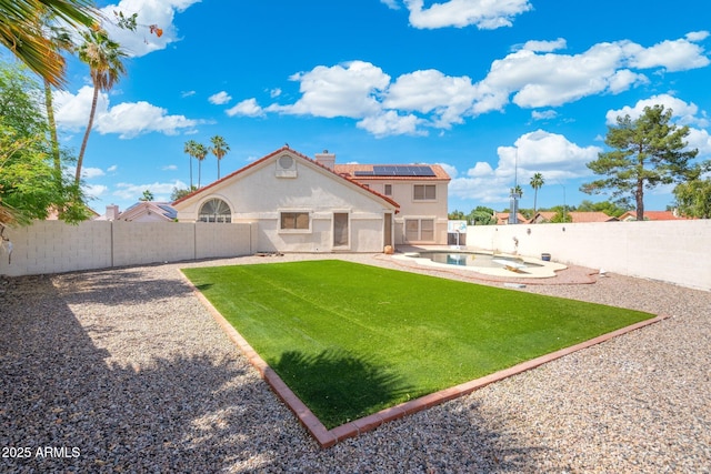 7503 W Julie Dr, Glendale, AZ 85308 - rear view of property featuring solar panels, stucco siding, a patio area, and a chimney