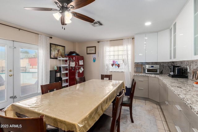 kitchen featuring white cabinetry, a wealth of natural light, light stone counters, and tasteful backsplash