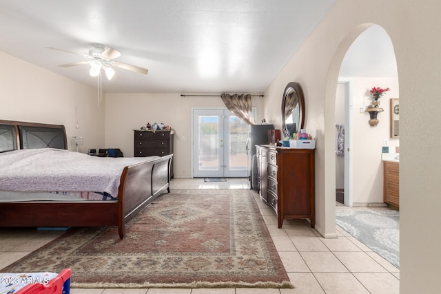 tiled bedroom with ceiling fan, ensuite bath, and access to outside