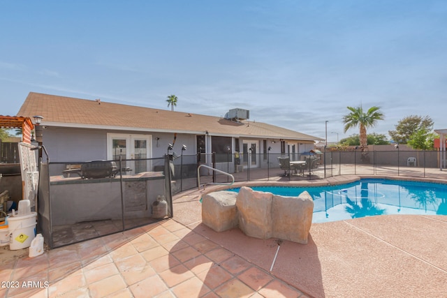 view of swimming pool with a patio area and french doors