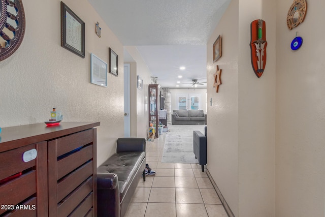 hallway with light tile floors and a textured ceiling