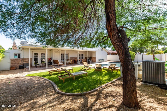 7440 E Hubbell St, Scottsdale, AZ 85257 - rear view of property featuring french doors, a fenced backyard, a patio area, stone siding, and a ceiling fan