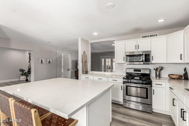 7440 E Hubbell St, Scottsdale, AZ 85257 - kitchen featuring stainless steel appliances, recessed lighting, a kitchen island, tasteful backsplash, and light wood-style floors