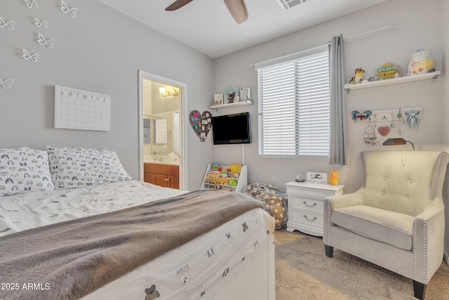 bedroom with ceiling fan, ensuite bathroom, and light carpet