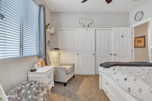 bedroom featuring light colored carpet, ceiling fan, and a closet