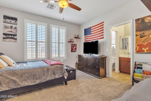 carpeted bedroom with connected bathroom and ceiling fan